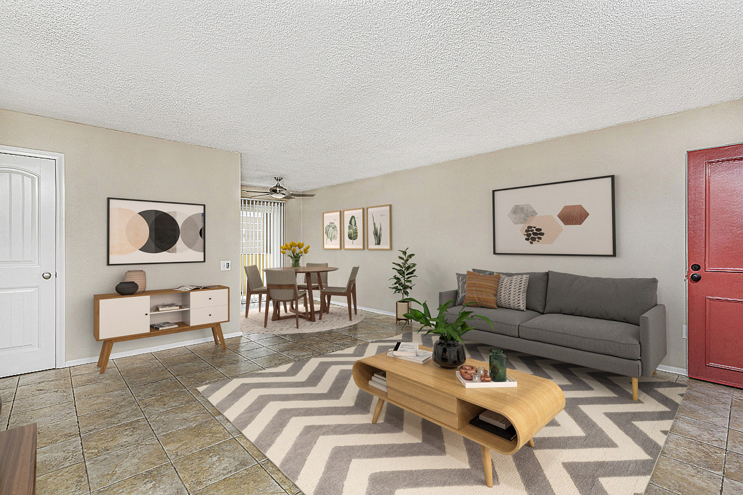 Living room with couch, coffee table and view of the entry door. Living room is in the distance with a table and four chairs at Pacific Sands, San Diego, CA